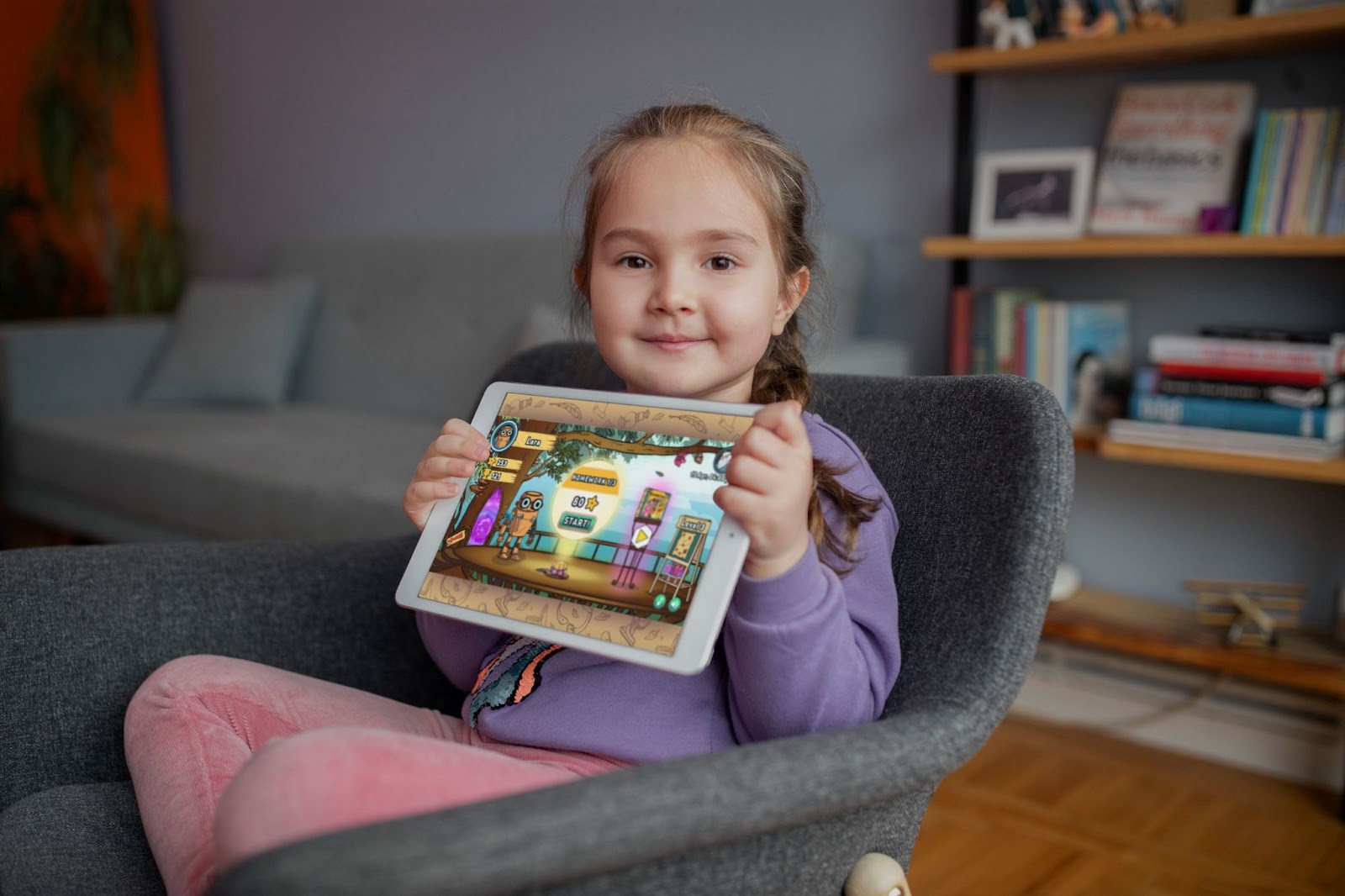 Fetiță cu o tabletă, luând lecții de engleză online la școala Novakid